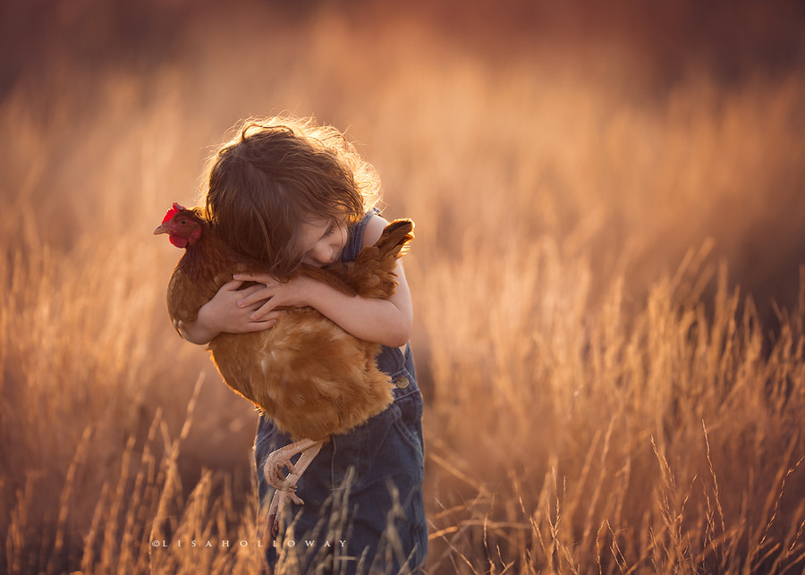 jeune garçon serrant une poule dans ses bras