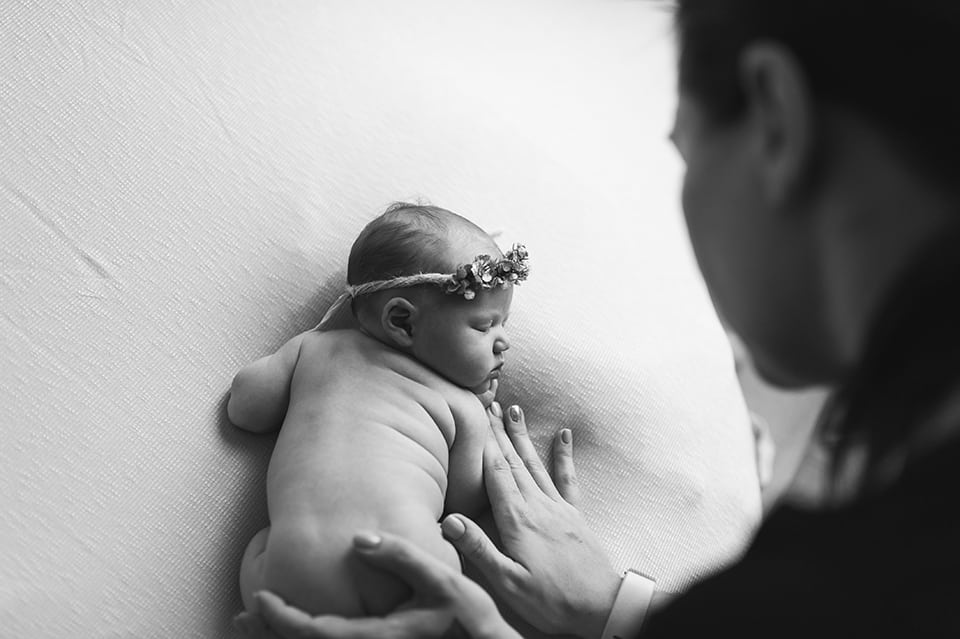La photographe pose le bébé pour une image artistique et intemporelle.