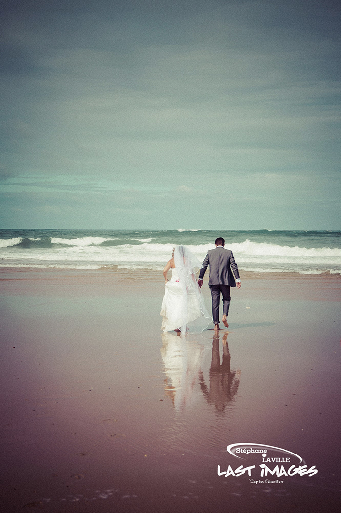 COuple de mariés marchant vers la mer