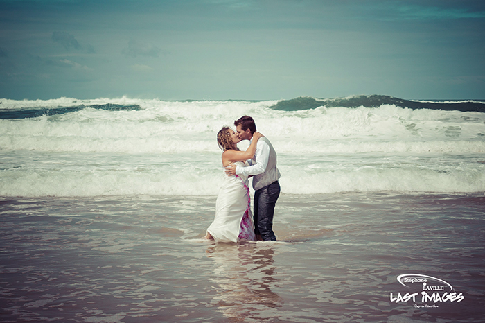 Couple de mariés qui s'embrassent sur la plage