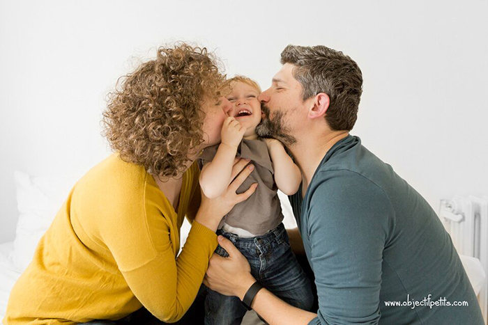 Portrait de famille faisant un bisous à son bébé