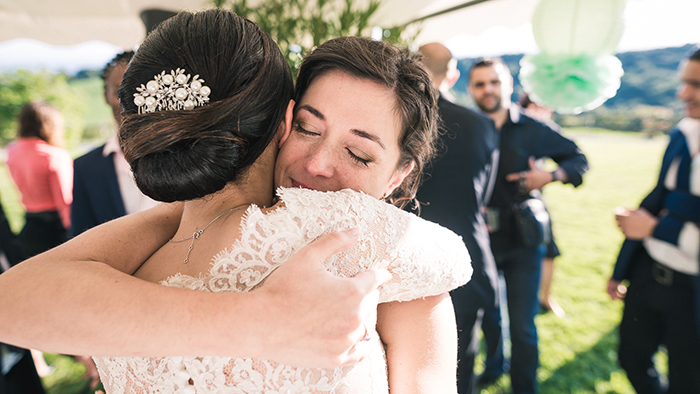 photo de mariage : une mariée enlace une invitée