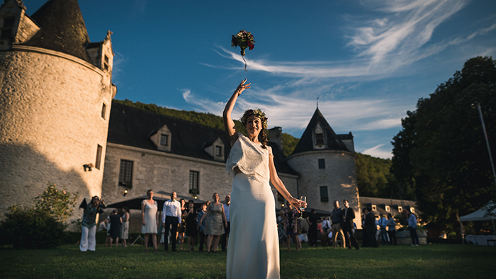 le lancé du bouquet de la mariée devant un château