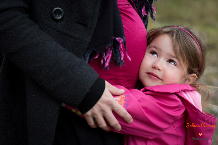 Photo de maternité : une future maman et sa fille qui sert son bidon dans ses bras