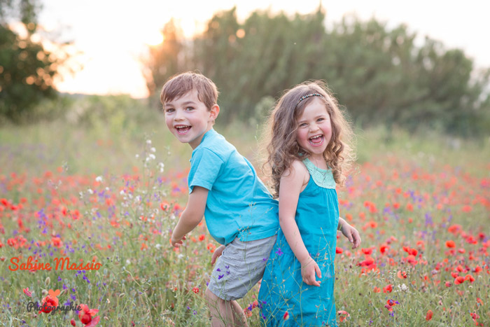 portrait d'enfants jouant dans un champ de coquelicots