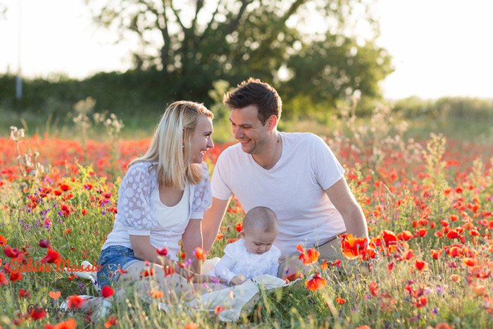 Séance photo d'une famille dans les champs de coquelicots.