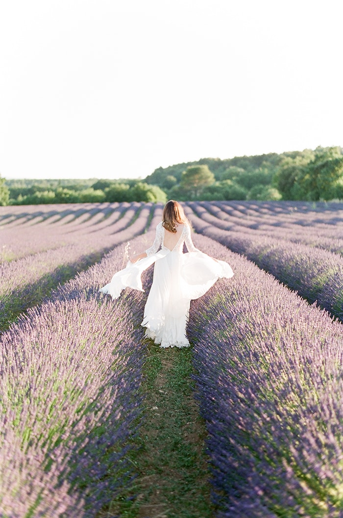 Photo d'une mariée dans un champ de lavande, les voiles au vent...