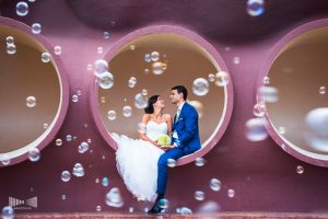 Photo issue d'un mariage : les mariés dans une bulle et entourés de bulles de savon.
