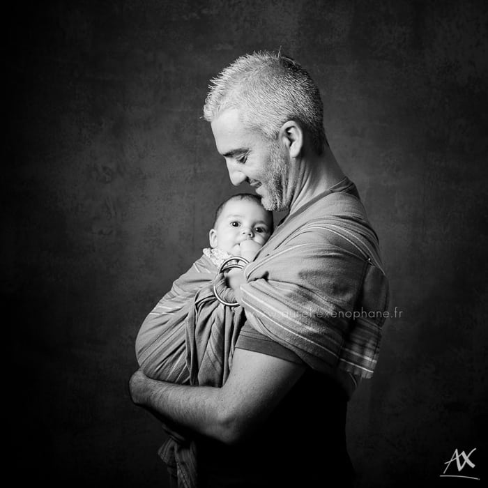 Le portage en écharpe d'un bébé par son papa. Le regard attendri 