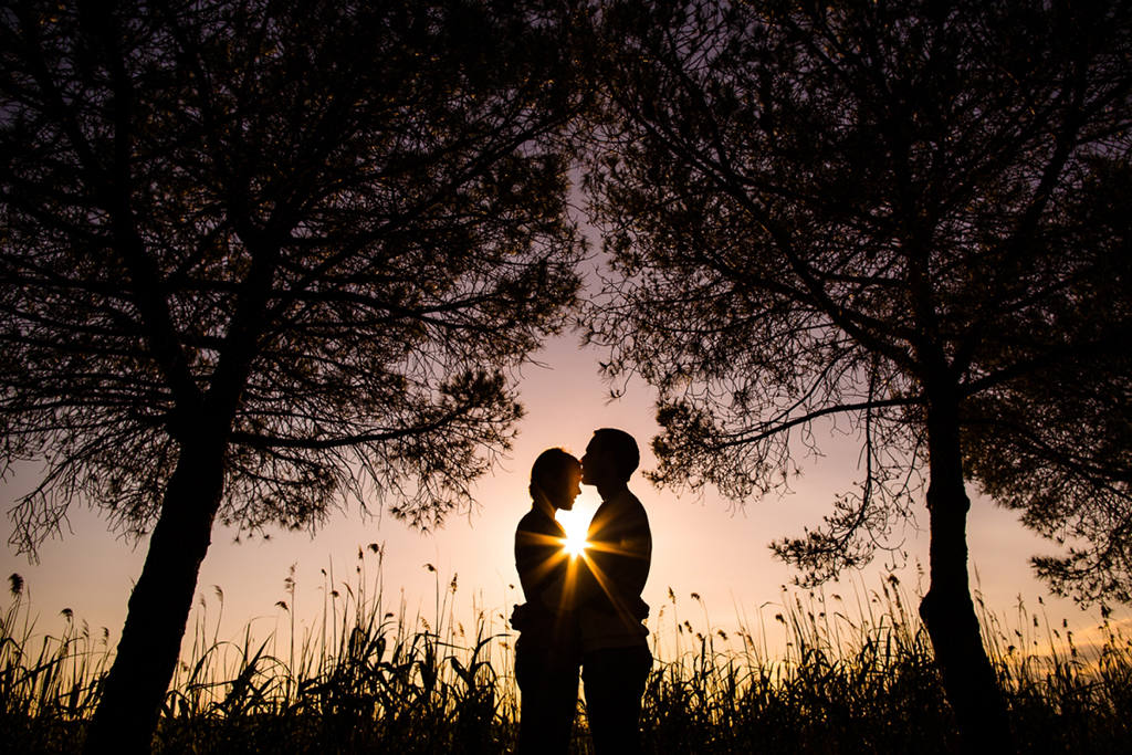 Photo de couple en contre-jour, le soleil forme une étoile entre-eux. Une image romantique de Caroline Vidal, photographe à Montpellier