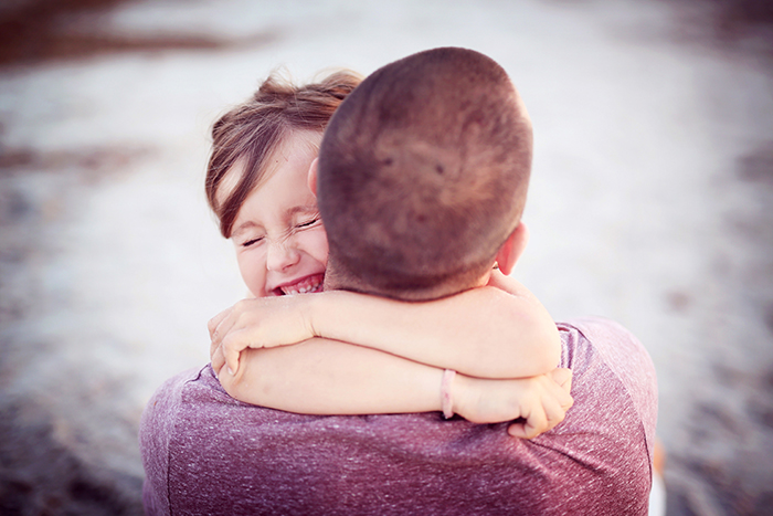 Petite fille qui sert très son papa dans les bras. Ils sont heureux.