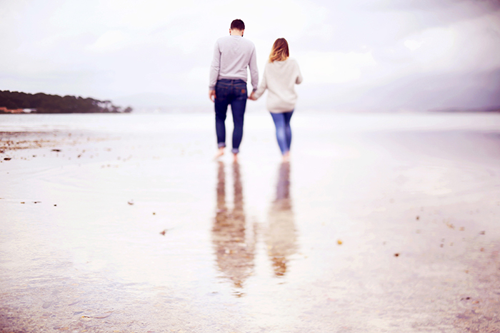 Séance photo de couple au bord de la mer, pendant une journée pluvieuse. Réalisée par Audrey Leguen.