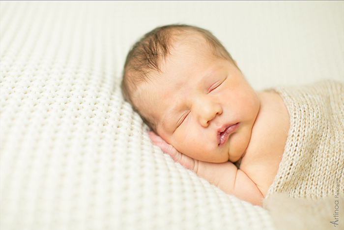Photographie de nouveau-né en studio, un bébé endormi et apaisé, serein.