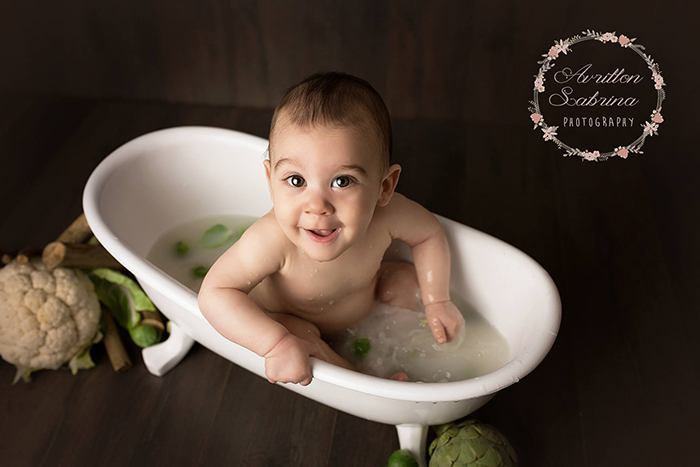 Petit garçon d'un an dans un petit bain de lait