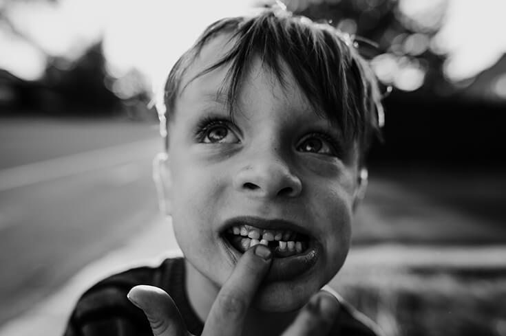 Gros plan d'un enfant en train de réfléchir. Une image noir et blanc, artistique, de Catherine Giroux.