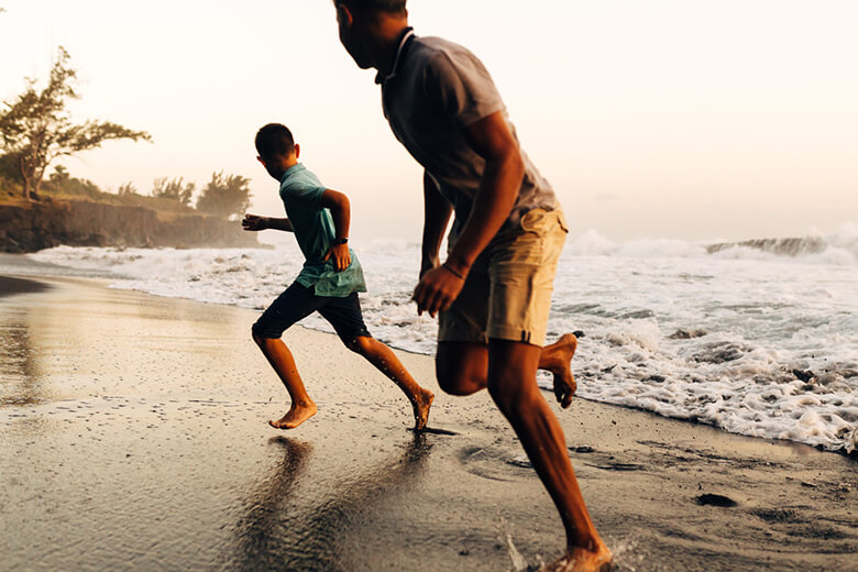 Un homme est son fils courant sur la plage